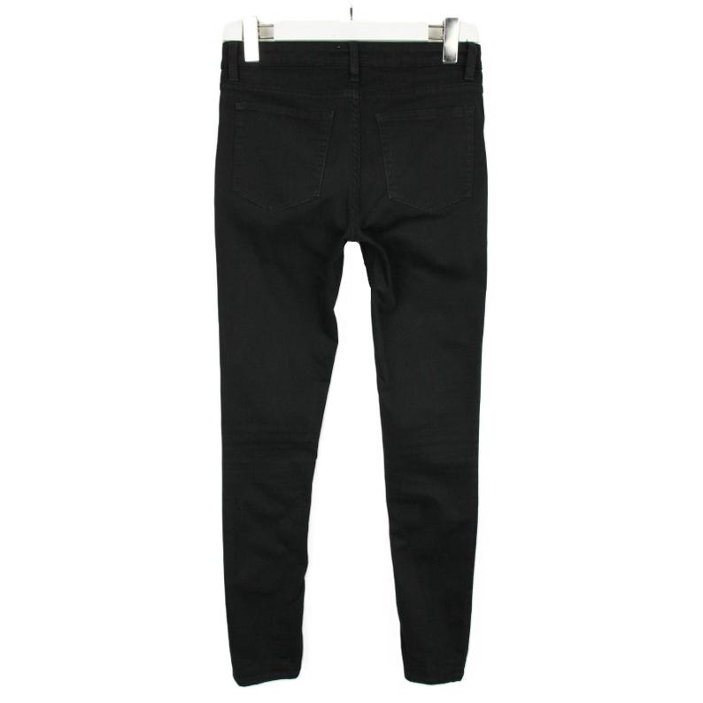 May include: A pair of solid black denim jeans shown from the back view. The pants feature a standard waistband with belt loops, two patch pockets on the rear, and a slim-fit leg design. The garment is displayed hanging from a white plastic hanger.