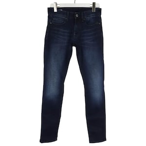 Könnte beinhalten: Eine dunkelblaue Jeans aus Denim mit klassischem Fünf-Taschen-Design, Knopf- und Reißverschluss sowie dezenter Waschung an den Oberschenkeln. Die Jeans hat einen geradlinigen Schnitt mit sichtbaren Nähten entlang der Taschen und Beine.