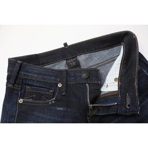 Peut inclure: Jean en denim bleu indigo fonc&eacute; avec une fermeture &agrave; boutons, des rivets en m&eacute;tal cuivr&eacute; et une petite poche gousset. L'int&eacute;rieur de la ceinture pr&eacute;sente une &eacute;tiquette noire de la marque True Religion. Le tissu pr&eacute;sente un d&eacute;lavage subtil.