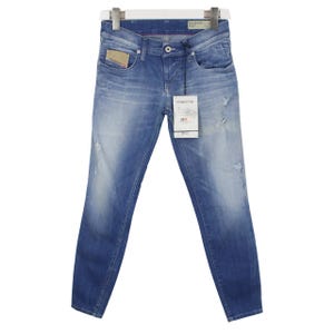 Op de afbeelding: Blauwe denim jeans met een vervaagde wassing en distressed details. De jeans hebben een klassiek vijf-zakken ontwerp, een knoop- en ritssluiting en een kleine logopatch. Een label met tekst hangt aan de jeans.