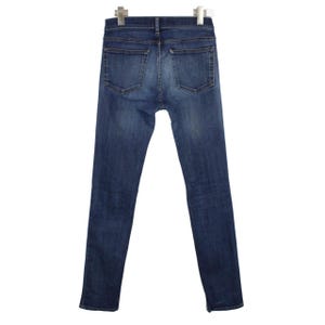 May include: A pair of dark blue denim jeans featuring a classic five-pocket design, a mid-rise waist, and a slim-fit leg silhouette. The fabric displays a subtle faded wash effect across the seat and thighs, with visible stitching details.