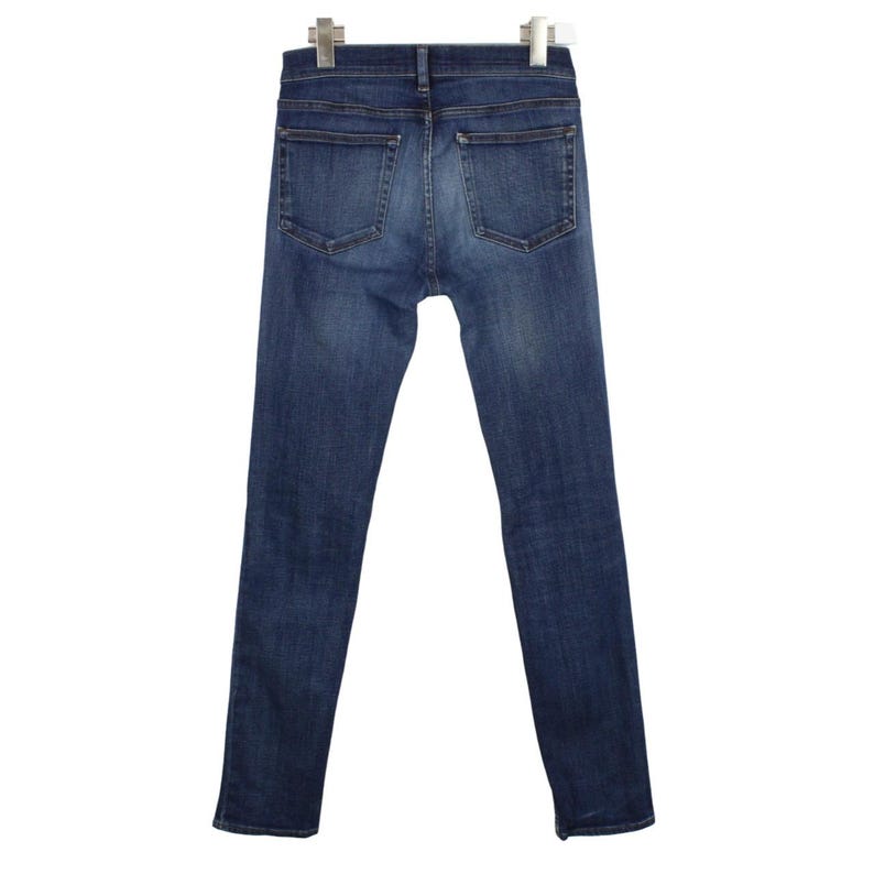 May include: A pair of dark blue denim jeans featuring a classic five-pocket design, a mid-rise waist, and a slim-fit leg silhouette. The fabric displays a subtle faded wash effect across the seat and thighs, with visible stitching details.