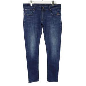Könnte beinhalten: Eine blaue Jeans aus Denim mit klassischem Fünf-Taschen-Design, Knopf- und Reißverschluss, Gürtelschlaufen und einem verwaschenen Effekt an den Oberschenkeln und Knien, präsentiert auf einem weißen Kleiderbügel vor weißem Hintergrund.