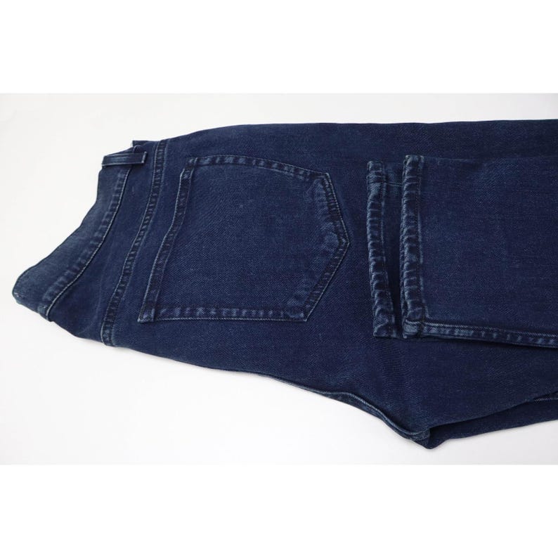 Pu&ograve; includere: Un paio di jeans in denim blu scuro caratterizzati da un classico design a cinque tasche con cuciture visibili lungo la tasca posteriore e la cintura. Il tessuto presenta un lavaggio indaco profondo con lievi sfumature e un bottone.