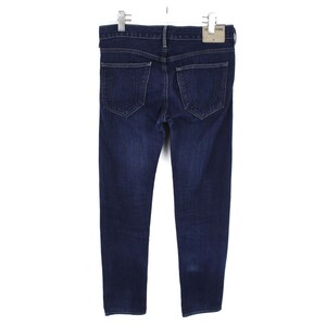 May include: Dark blue denim jeans featuring a classic five-pocket design with a button fly and belt loops. The back pockets display a signature horseshoe-shaped stitch pattern in a matching thread color. A light-colored leather brand patch is attached.