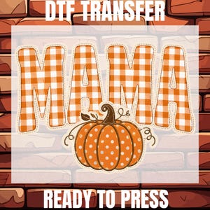 May include: A DTF transfer sheet featuring the word MAMA in an orange and white gingham pattern. Below the text is an orange pumpkin with white polka dots and brown stem details. The text DTF TRANSFER and READY TO PRESS is visible.