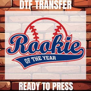 May include: A red, white, and blue baseball-themed iron-on transfer design that says "Rookie of the Year". The design features a baseball with stitching and a blue and red banner with the text. The design is ready to press.