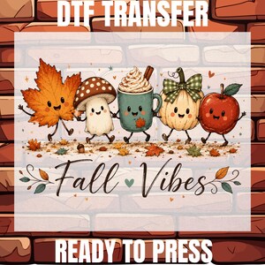 May include: A DTF transfer ready to press featuring a cartoon autumn scene with a maple leaf, mushroom, mug of cocoa, pumpkin, and apple. The text reads DTF TRANSFER, Fall Vibes, and READY TO PRESS. The characters have smiling faces and limbs.