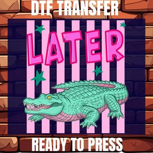 May include: A colorful graphic featuring a teal alligator with pink accents, set against a pink and white striped background. The word "LATER" is in pink bubble letters. Green star shapes are scattered around the text and alligator. The words "DTF TRANSFER" and "READY TO PRESS" are at the top and bottom.