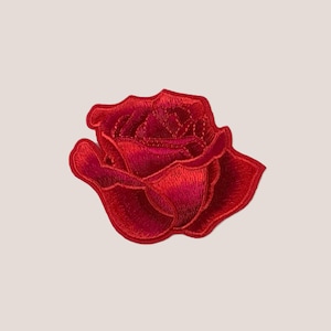 以下が含まれることがあります： 赤い刺繍のバラのパッチ。バラは愛と美の古典的なシンボルです。