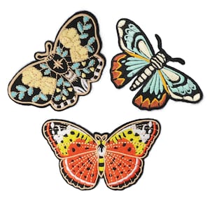 May include: Three embroidered butterfly patches in various colors. One butterfly has yellow and blue accents on a black background. Another has blue, orange, and black details. The third butterfly features red, yellow, and orange hues.