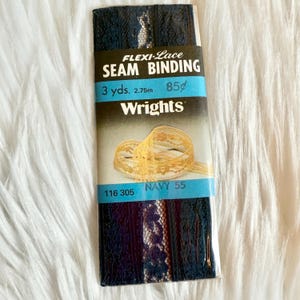May include: Navy blue Flexi-Lace seam binding by Wrights. The package reads "3 yds." and "NAVY 55". The lace is a dark blue with a delicate floral pattern. The packaging also shows a sample of the lace.