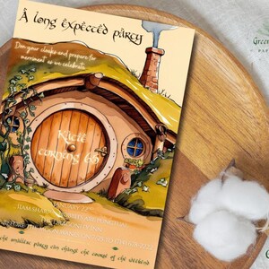 May include: A whimsical invitation card featuring a hobbit hole illustration with a round wooden door and a chimney. The text reads "A long expected party" and includes event details. The card is on a wooden tray.