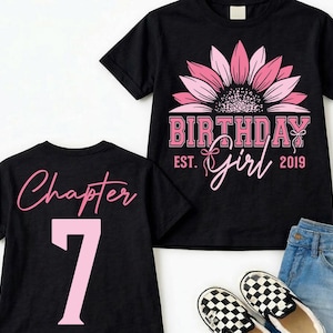 May include: Black t-shirts with pink text and graphics. One shirt says "Birthday Girl" with a sunflower design. The other shirt says "Chapter 7". The shirts are paired with denim shorts and checkered slip-on shoes.