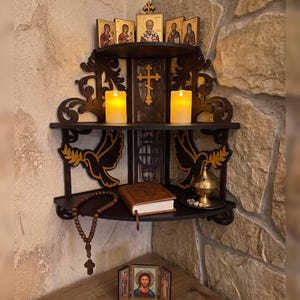 May include: Dark brown corner shelf with religious icons, candles, and a book. The shelf features decorative cutouts of doves and a cross. A rosary and incense burner are also visible.