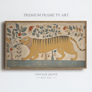 May include: A rectangular framed wall art piece titled PREMIUM FRAME TV ART by VINTAGE GROVE Art Co. The artwork features a stylized yellow tiger with black stripes walking past botanical trees with orange and blue fruit on a beige background.