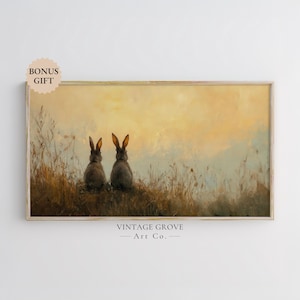 May include: A painting of two brown rabbits sitting in a field of tall grass, looking out at a sunset. The sky is a soft yellow and orange, and the grass is a muted green. The rabbits are facing away from the viewer, and their ears are perked up.