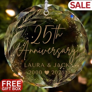 Op de afbeelding: Een heldere, facetgeslepen glazen ornament met een zilveren ophanglus. Het ornament heeft de tekst "25th Anniversary" met de namen "Laura & Jack" en de jaren "2000 2025". Goudblad en glitter accentueren het ontwerp. Het woord "SALE" is zichtbaar.
