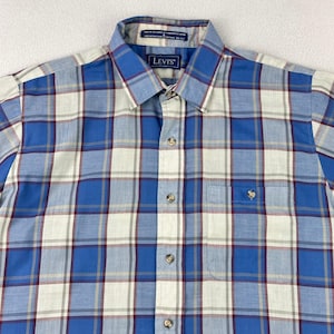 May include: A button-down shirt with a blue, white, and burgundy plaid pattern. The shirt has a button-down collar, a chest pocket, and the Levi's logo on the collar. The shirt is made of a lightweight fabric.