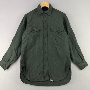 May include: A long-sleeve button-down shirt in a solid dark forest green color. The shirt features a standard collar, a full-length front button placket, two chest pockets with buttoned flaps, and long sleeves with buttoned cuffs and a curved hem.