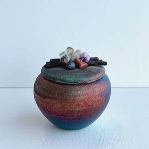 May include: A white ceramic mug with a black handle and the text "But First, Coffee" in a black, bold font. The mug is sitting on a white surface. The mug is approximately 4 inches tall.