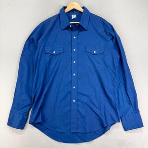 May include: A long-sleeved, cobalt blue shirt with a classic Western design. Features two chest pockets with button closures, a pointed collar, and white buttons down the front. The shirt is hanging on a wooden hanger.