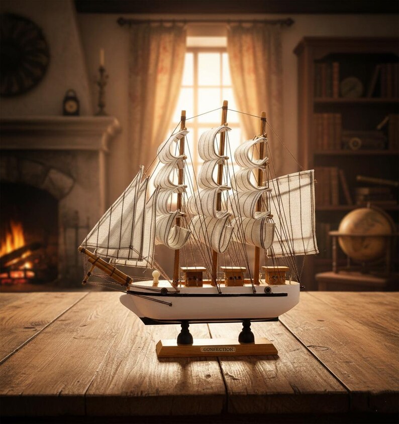 May include: A detailed model sailboat with white sails and a white hull, displayed on a wooden table. The model features multiple masts and rigging, with a wooden base. The background includes a fireplace and a bookshelf.