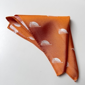 May include: A folded orange pocket square with a white sailboat pattern.