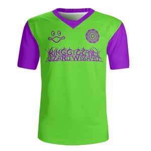 May include: A green and purple short-sleeved t-shirt with a graphic design of a smiling face, a geometric pattern, and the text "RINGGOCORP LIZARDWIZARD".