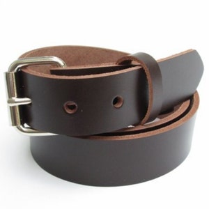 May include: A brown leather belt with a silver buckle. The belt is rolled up and the buckle is visible.
