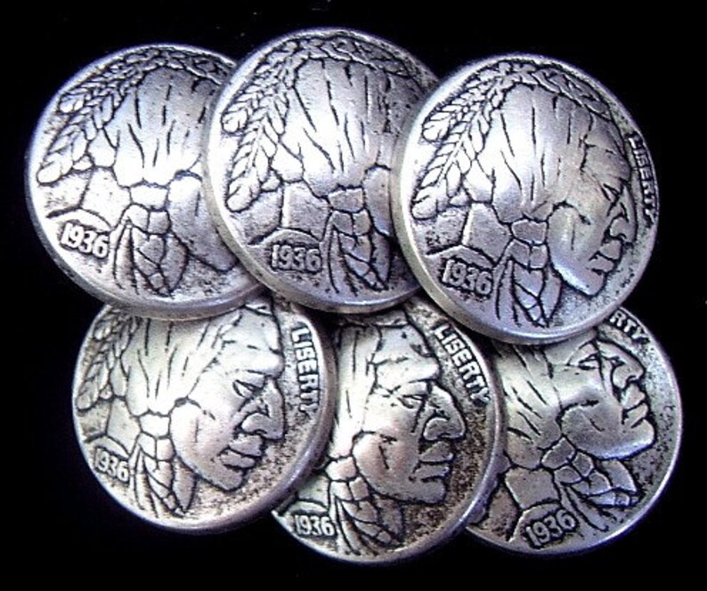 May include: A collection of seven silver-toned Buffalo nickels, each displaying a profile of a Native American and the year 1936. The word "LIBERTY" is visible on some coins. The nickels are stacked against a black background.