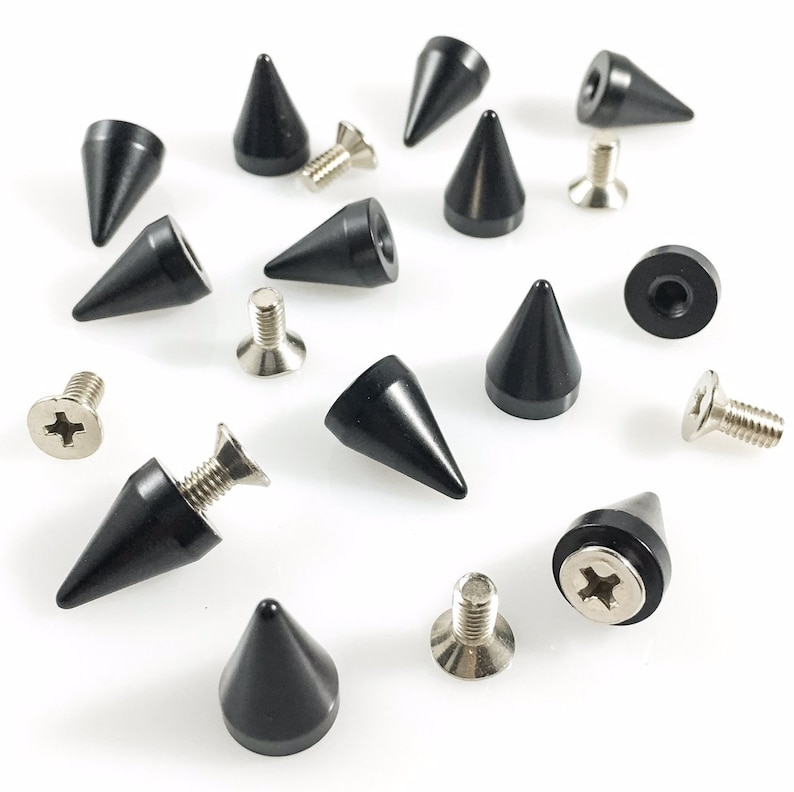 May include: A set of 14 black metal pyramid studs with silver screws. The studs are approximately 2.5 cm tall and have a sharp point. The screws are about 1.25 cm long.