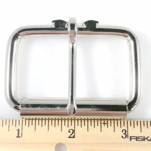 May include: Silver metal buckle for a belt, measuring 1 inch wide. The buckle is designed to be used with a 1 inch wide belt.