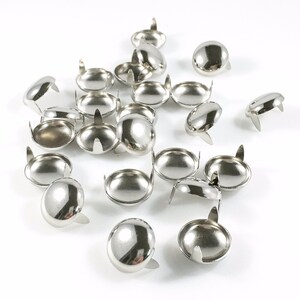 Puede incluir: Una colecci&oacute;n de patas de muebles de metal plateadas con una parte superior redondeada y tres puntas. Las patas est&aacute;n esparcidas sobre una superficie blanca.