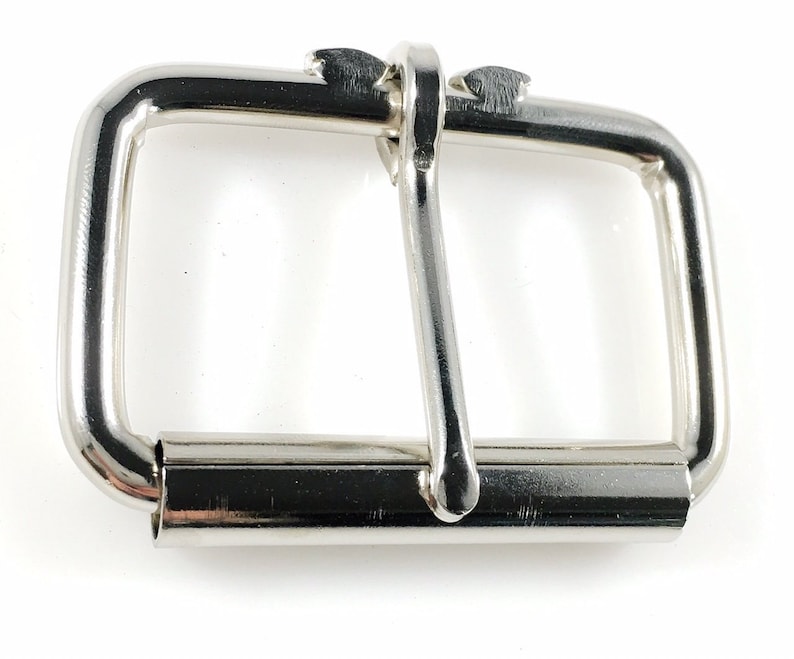 May include: A silver metal buckle with a rectangular shape and a smooth finish.