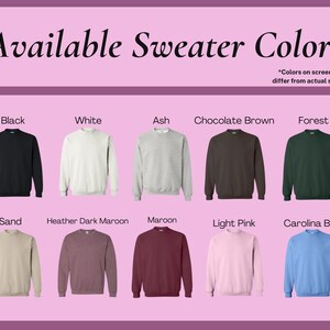 May include: A display of crewneck sweaters in various colors, including black, white, ash, chocolate brown, forest green, sand, heather dark maroon, maroon, light pink, and carolina blue. The text "Available Sweater Colors" is at the top.