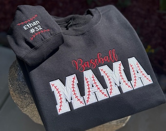 May include: Black sweatshirt with white and red embroidered baseball stitching that reads "Baseball Mama". A smaller black hat with red stitching is included with the text "Ethan #32" embroidered on it.