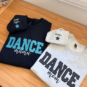 May include: Two sweatshirts and two matching beanies. One navy blue sweatshirt with "DANCE mama" in turquoise lettering and a matching beanie with "Aspyn Pyper" and a star. The other is gray with "DANCE mom" in black lettering and a matching beanie with "Parker" and a star.