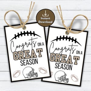 Puede incluir: Dos etiquetas de regalo con temática de fútbol americano. Cada etiqueta tiene un borde negro, un gráfico de balón de fútbol y las palabras "Congrats on a GREAT SEASON" en negro y beige. Incluye ilustraciones de balón de fútbol y casco.