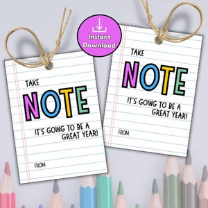 May include: Two white paper tags with the words "TAKE NOTE" in colorful letters and "IT'S GOING TO BE A GREAT YEAR!" printed on them. Each tag has a brown string attached. A pink circle with "Instant Download" is also visible.