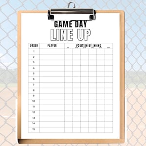 May include: A clipboard with a white sheet of paper featuring a baseball lineup chart. The chart includes sections for "Order," "Player," and "Position by Inning." The words "Game Day Line Up" are printed at the top in bold, black letters.