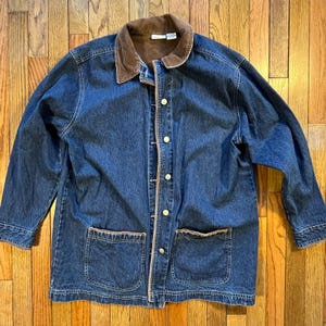May include: A blue denim jacket with a brown corduroy collar and two front pockets. The jacket has a button-up closure and long sleeves. The jacket is made of a sturdy denim material.