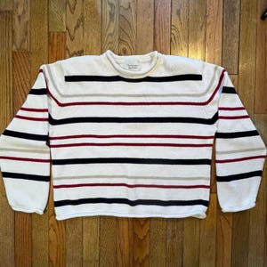 May include: White sweater with horizontal stripes in navy, burgundy, black, and tan. The sweater has a crew neck and long sleeves. The brand name "Christopher & Banks" is visible on the label.