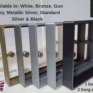 May include: A row of rectangular light switch wall plates in white, bronze, gun grey, metallic silver, and black. The text reads: Available in: White, Bronze, Gun grey, Metallic Silver, Standard Silver & Black, JRM STUDIOS, 1 Gang & 2 Gang available.