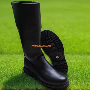 Puede incluir: Botas negras de cuero de caña alta con suela gruesa y punta puntiaguda. Las botas tienen una cremallera en el interior del eje.