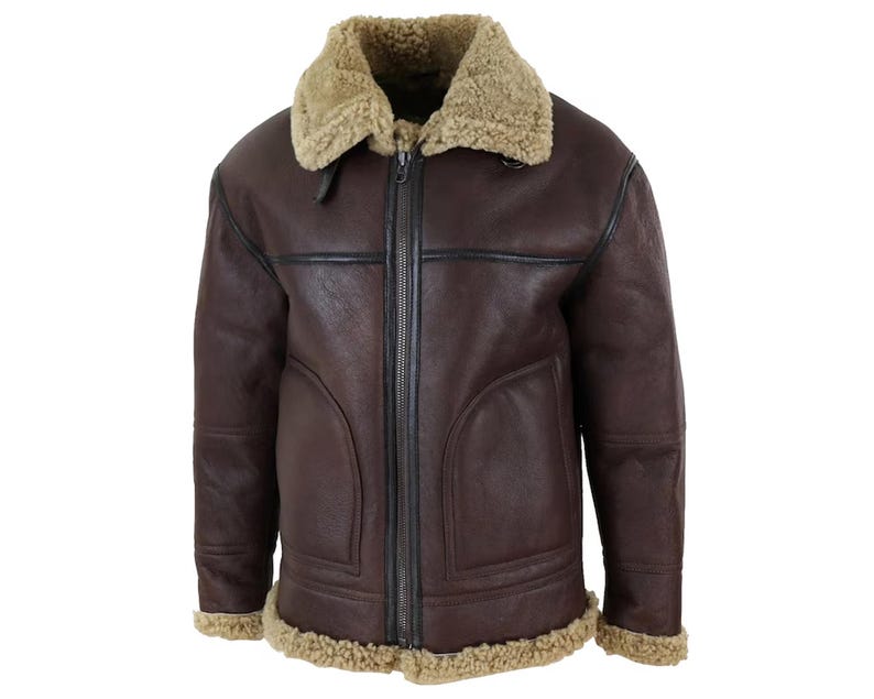May include: A brown leather jacket with a shearling collar and lining. The jacket has a full zipper closure and shearling trim along the cuffs and hem. The jacket has a classic aviator style.