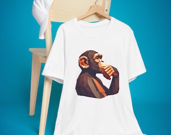 May include: White t-shirt with a graphic of a brown and orange geometric chimpanzee thinking.
