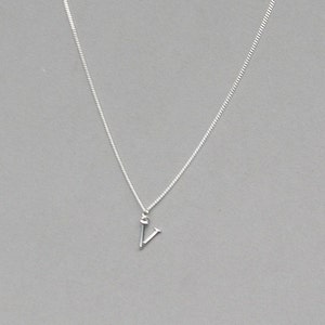 May include: A silver chain necklace with a small silver letter V pendant.