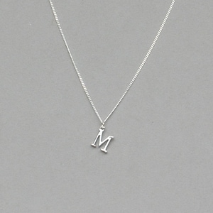 May include: A silver chain necklace with a silver letter M pendant.