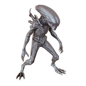 May include: A gray Xenomorph action figure, a creature with a skeletal appearance, elongated head, and sharp claws. The figure is posed in a dynamic stance, with its arms and legs slightly bent, ready for action. The figure is a collectible item.